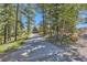 A home set back from the road with a long private driveway and wooden signpost at 10450 Hondah Dr, Littleton, CO 80127