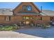 Charming front porch featuring decorative details, hanging plants, and log cabin siding at 10450 Hondah Dr, Littleton, CO 80127