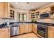 Bright kitchen featuring stainless steel appliances, light wood cabinets, and window views at 10450 Hondah Dr, Littleton, CO 80127