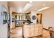 Bright, open kitchen with wood cabinets, island, stainless appliances, and skylights at 10450 Hondah Dr, Littleton, CO 80127