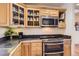 Updated kitchen with wood cabinets, stainless steel appliances, and black countertops at 10450 Hondah Dr, Littleton, CO 80127