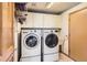 Functional laundry room equipped with modern washer, dryer, and ample storage at 10450 Hondah Dr, Littleton, CO 80127