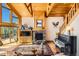 Inviting living room with stone fireplace, wooden ceilings and grand piano at 10450 Hondah Dr, Littleton, CO 80127