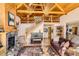 Cozy living room with stone fireplace, wooden ceilings, piano and stairway at 10450 Hondah Dr, Littleton, CO 80127