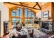 Stunning living room with vaulted wood ceilings, stone fireplace, and mountain views at 10450 Hondah Dr, Littleton, CO 80127