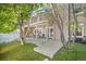 View of backyard featuring a covered deck, outdoor seating, manicured lawn, mature trees, and privacy fence at 9875 Greensview Cir, Lone Tree, CO 80124