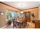 Elegant dining room with wooden table and chairs, hardwood floors, bay window, and decorative cabinet at 9875 Greensview Cir, Lone Tree, CO 80124