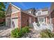 Charming exterior view of a two-story house with a brick facade, attached garage, and landscaped front yard at 9875 Greensview Cir, Lone Tree, CO 80124
