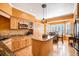 Spacious kitchen with wooden cabinets, granite counters, kitchen island, modern appliances, and adjacent dining area at 9875 Greensview Cir, Lone Tree, CO 80124