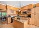 Well-lit kitchen with wooden cabinets, granite countertops, stainless steel appliances, and island with pendant lighting at 9875 Greensview Cir, Lone Tree, CO 80124