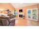 Comfortable living room with fireplace, hardwood floors, cozy furniture, and natural light, with backyard access at 9875 Greensview Cir, Lone Tree, CO 80124