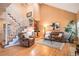 Inviting living room featuring hardwood floors, staircase, comfortable furniture, and natural lighting at 9875 Greensview Cir, Lone Tree, CO 80124
