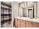 Bathroom featuring a double sink vanity with a large mirror and a shower with a patterned curtain at 527 Stonemont Dr, Castle Pines, CO 80108