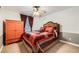 Cozy bedroom with patterned bedspread, red curtains, carpet, ceiling fan, and an orange armoire at 527 Stonemont Dr, Castle Pines, CO 80108