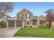 Charming two-story home featuring a well-manicured lawn and a three-car garage, set against a clear blue sky at 527 Stonemont Dr, Castle Pines, CO 80108