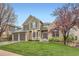 Charming two-story home featuring a well-manicured lawn and a three-car garage, set against a clear blue sky at 527 Stonemont Dr, Castle Pines, CO 80108