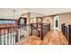 Open hallway with hardwood floors, iron railing, and a hanging light fixture at 527 Stonemont Dr, Castle Pines, CO 80108