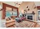 Comfortable living room with a brick fireplace, large windows, and hardwood floors at 527 Stonemont Dr, Castle Pines, CO 80108