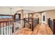 Open loft area featuring hardwood floors, decorative railing, and view of the lower level at 527 Stonemont Dr, Castle Pines, CO 80108