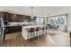 Modern kitchen with dark cabinets, stainless steel appliances, a large island, and a dining area at 13960 Hanging Lake St, Parker, CO 80138