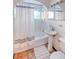 Clean bathroom, featuring a pedestal sink, tub shower, and updated fixtures at 2590 S Meade St, Denver, CO 80219