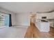 A large open living room with carpet, a view to the deck and the kitchen, complete with modern appliances at 3845 Canyon Ranch Rd # 102, Highlands Ranch, CO 80126