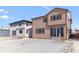 View of the home's backyard featuring snowy yard, sliding glass door and tan and white siding at 9165 Truckee Ct, Commerce City, CO 80022