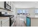 Well-equipped kitchen with stainless steel appliances, white cabinets, and a large sliding glass door at 9165 Truckee Ct, Commerce City, CO 80022