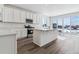 Modern kitchen with white cabinetry, stainless steel appliances, and center island with quartz countertops at 9165 Truckee Ct, Commerce City, CO 80022