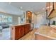 Bright kitchen featuring wood cabinets, granite countertops, stainless appliances, and an adjacent living space at 31112 Black Eagle Dr # 101, Evergreen, CO 80439