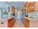 Well-lit kitchen featuring wooden cabinets, granite countertops, stainless steel appliances, and wood flooring at 31112 Black Eagle Dr # 101, Evergreen, CO 80439