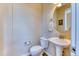 Charming powder room featuring a pedestal sink, round mirror, and neutral color scheme at 31112 Black Eagle Dr # 101, Evergreen, CO 80439