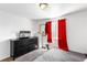A furnished carpeted bedroom with a dresser, television, and neutral colors at 19804 E Villanova Pl, Aurora, CO 80013