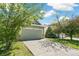 View of a two car garage and driveway of a home with mature shade trees at 19804 E Villanova Pl, Aurora, CO 80013