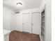 A finished carpeted hallway area with a view of the doors and built in storage at 19804 E Villanova Pl, Aurora, CO 80013