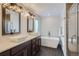 Modern bathroom with double vanity, soaking tub, and glass-enclosed shower at 4728 S Acoma St, Englewood, CO 80110
