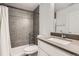 Updated bathroom with gray tiled walls, a new vanity, and modern fixtures in the shower at 4728 S Acoma St, Englewood, CO 80110