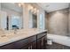 Bathroom featuring a double vanity, tiled shower/tub, and modern lighting at 4728 S Acoma St, Englewood, CO 80110