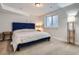 Comfortable bedroom featuring a blue headboard, soft carpeting, and natural light from the window at 4728 S Acoma St, Englewood, CO 80110
