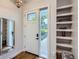 Bright entryway with a white door, built-in shelving, and decorative mirror, wood flooring at 4728 S Acoma St, Englewood, CO 80110