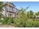 Exterior view of charming townhomes with balconies, set behind a black metal fence at 4728 S Acoma St, Englewood, CO 80110