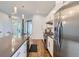 Spacious kitchen featuring white cabinets, stainless steel appliances, and a large center island at 4728 S Acoma St, Englewood, CO 80110