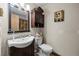 Cozy bathroom featuring a wood cabinet sink, modern toilet, and decorative wall art at 59 S De Gaulle St, Aurora, CO 80018