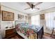 Charming bedroom featuring hardwood floors, a ceiling fan, and a large bed with an eye-catching floral pattern at 59 S De Gaulle St, Aurora, CO 80018