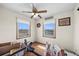 Well lit bedroom, featuring hardwood floors, a ceiling fan, two windows, and various equipment at 59 S De Gaulle St, Aurora, CO 80018
