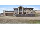 Two-story house with a deck over the garage, stairs to entry, and a fenced yard at 59 S De Gaulle St, Aurora, CO 80018