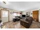 Welcoming living room with large, comfortable leather sofas, a decorative brick accent wall and tile floors at 59 S De Gaulle St, Aurora, CO 80018