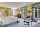 Bright bedroom with yellow walls, carpet flooring, and light blue, floral-patterned curtains at 199 Lafayette St, Denver, CO 80218