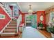 Inviting foyer with a decorative chandelier, open staircase, hardwood floors, and bright red walls at 199 Lafayette St, Denver, CO 80218