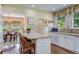 Well-lit kitchen with a center island, granite countertops, white cabinetry, and a view to the dining area at 199 Lafayette St, Denver, CO 80218